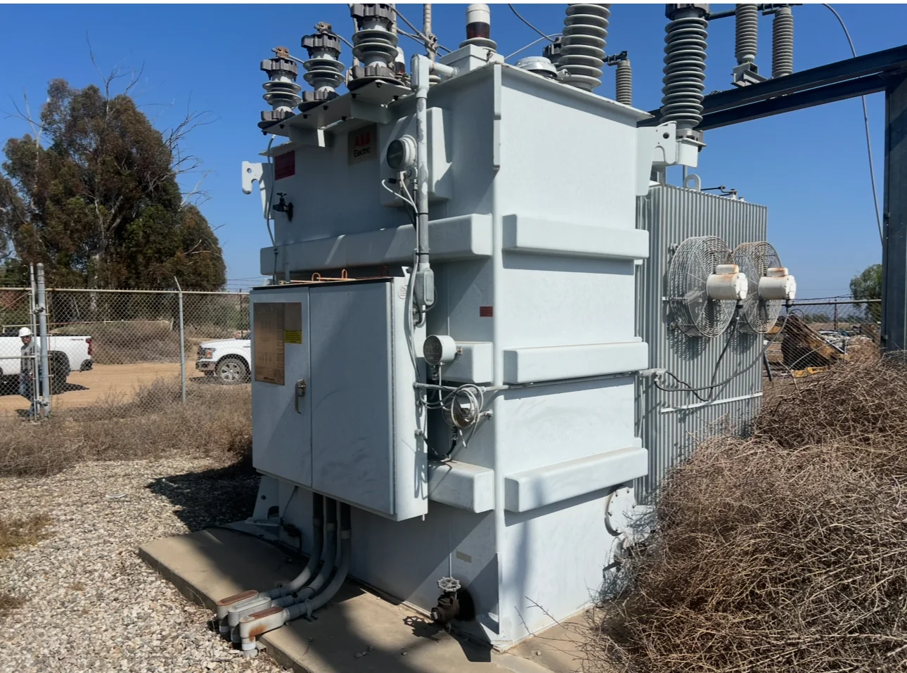 Large electrical transformer in an industrial yard at dawn