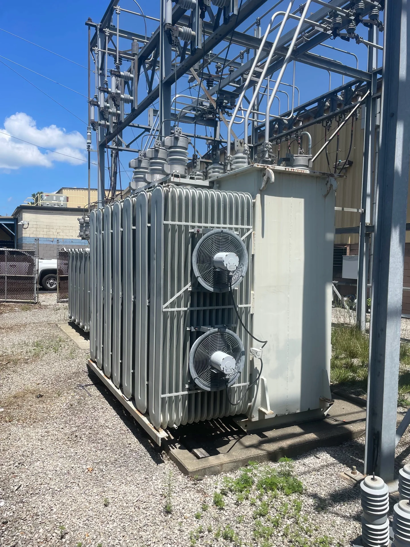 Large liquid-filled substation transformer installed below switchyard equipment