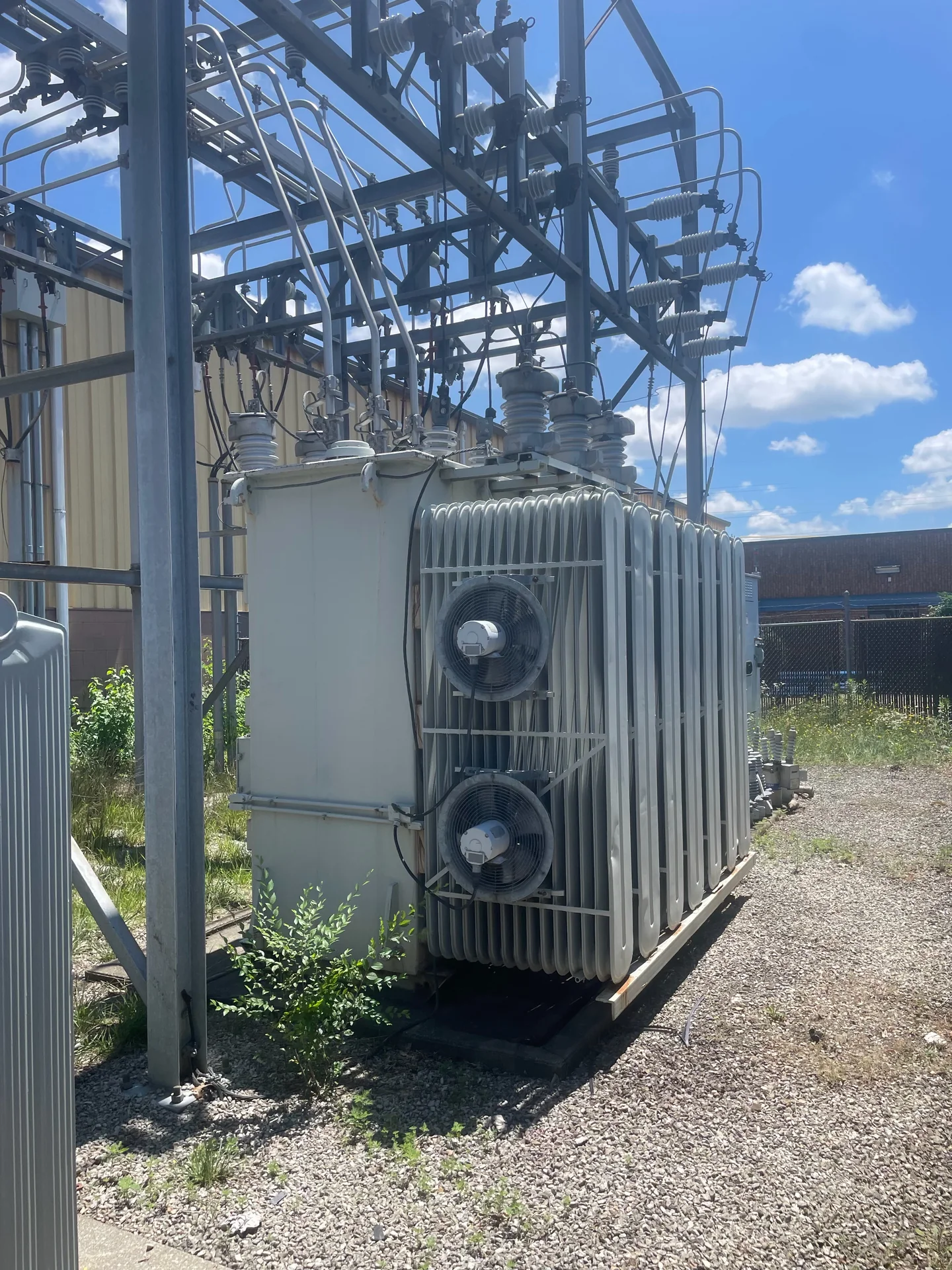 Side view of a liquid-filled transformer with cooling radiators and fans